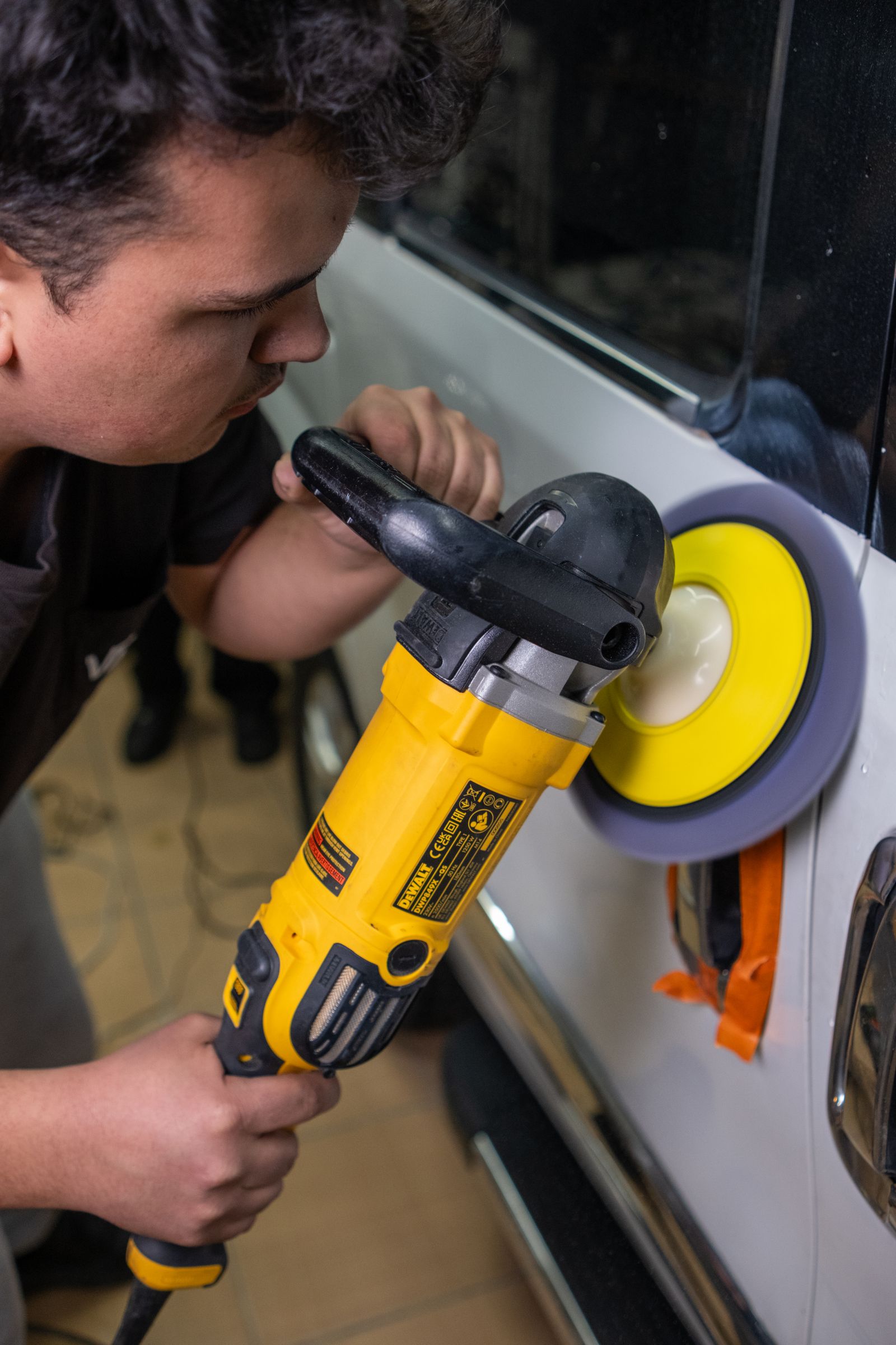 Technician polishing automotive paint