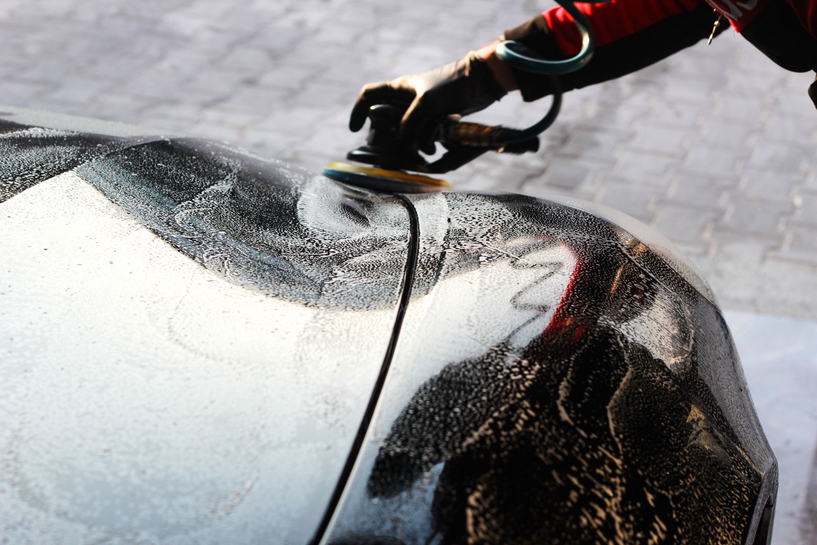 Technician applying finish protection to a vehicle